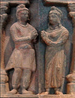 A Kushan couple (man left, woman right), posing as devotees in a Buddhist frieze, 2nd century.